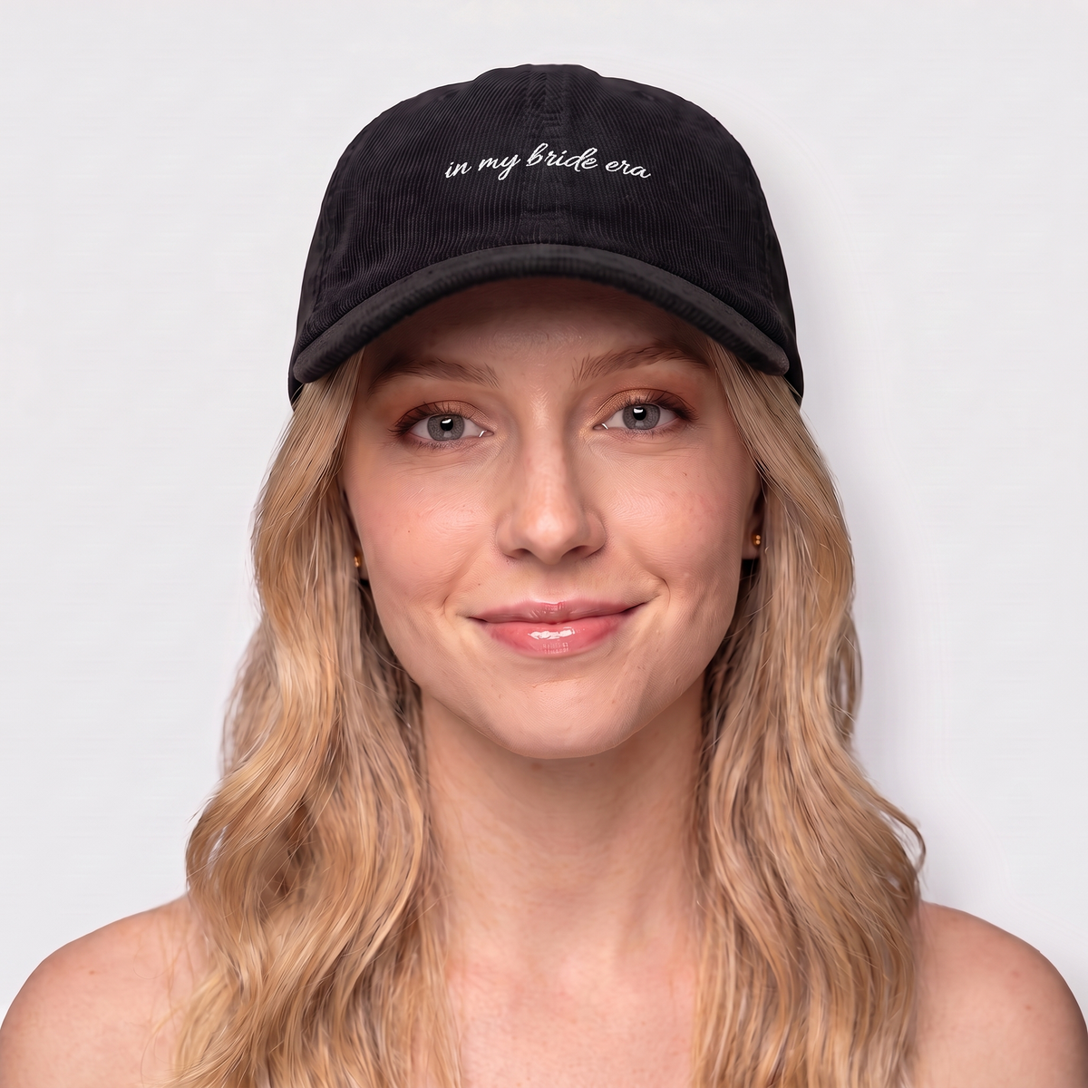 Woman wearing a black corduroy hat embroidered 'in my bride era' — Taylor Swift Eras-inspired bachelorette cap

