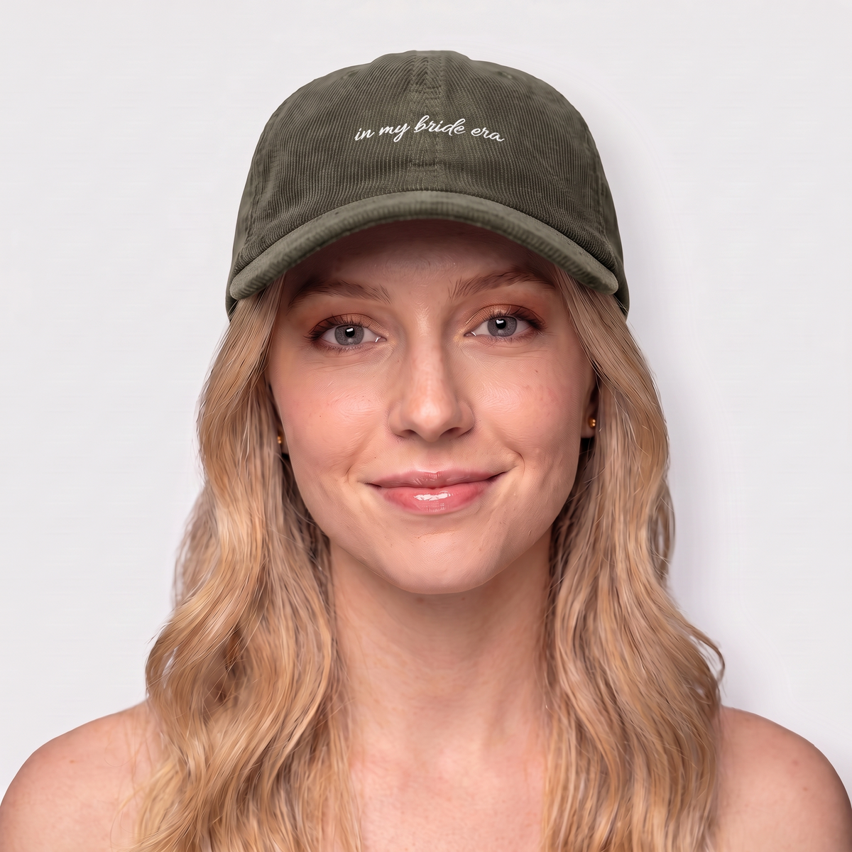 Woman wearing an olive corduroy hat embroidered 'in my bride era' — Taylor Swift Eras-inspired bachelorette cap

