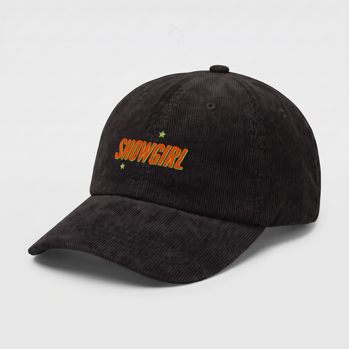 A black corduroy baseball cap featuring the word 'SHOWGIRL' embroidered in orange on the front, accented with two small green stars, set against a plain white background.
