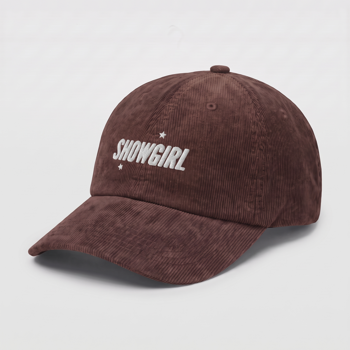 A brown corduroy baseball cap with 'SHOWGIRL' embroidered in white on the front, accented by two small white stars, shown on a plain white background.