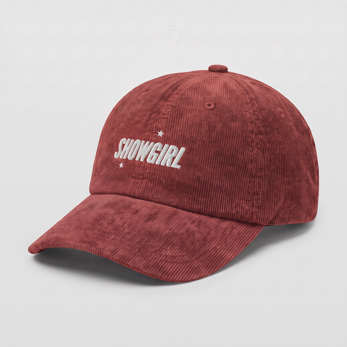 A burgundy corduroy baseball cap with 'SHOWGIRL' embroidered in white on the front, accented by two small white stars, shown on a plain white background.