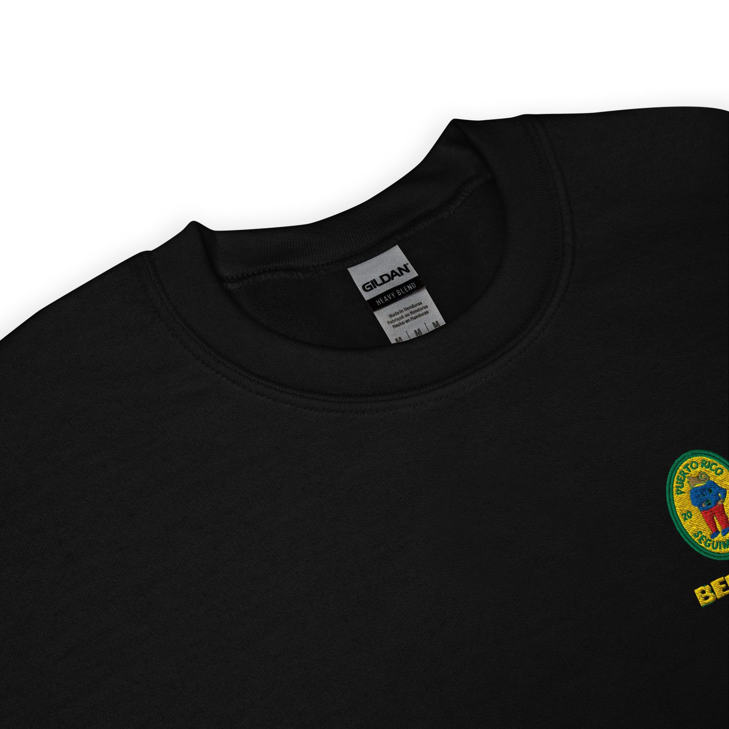 Black crewneck sweatshirt with small colorful embroidered ‘Benito’ crest logo on the chest, inspired by Bad Bunny merchandise, DtMF era streetwear, and minimalist tour-style apparel