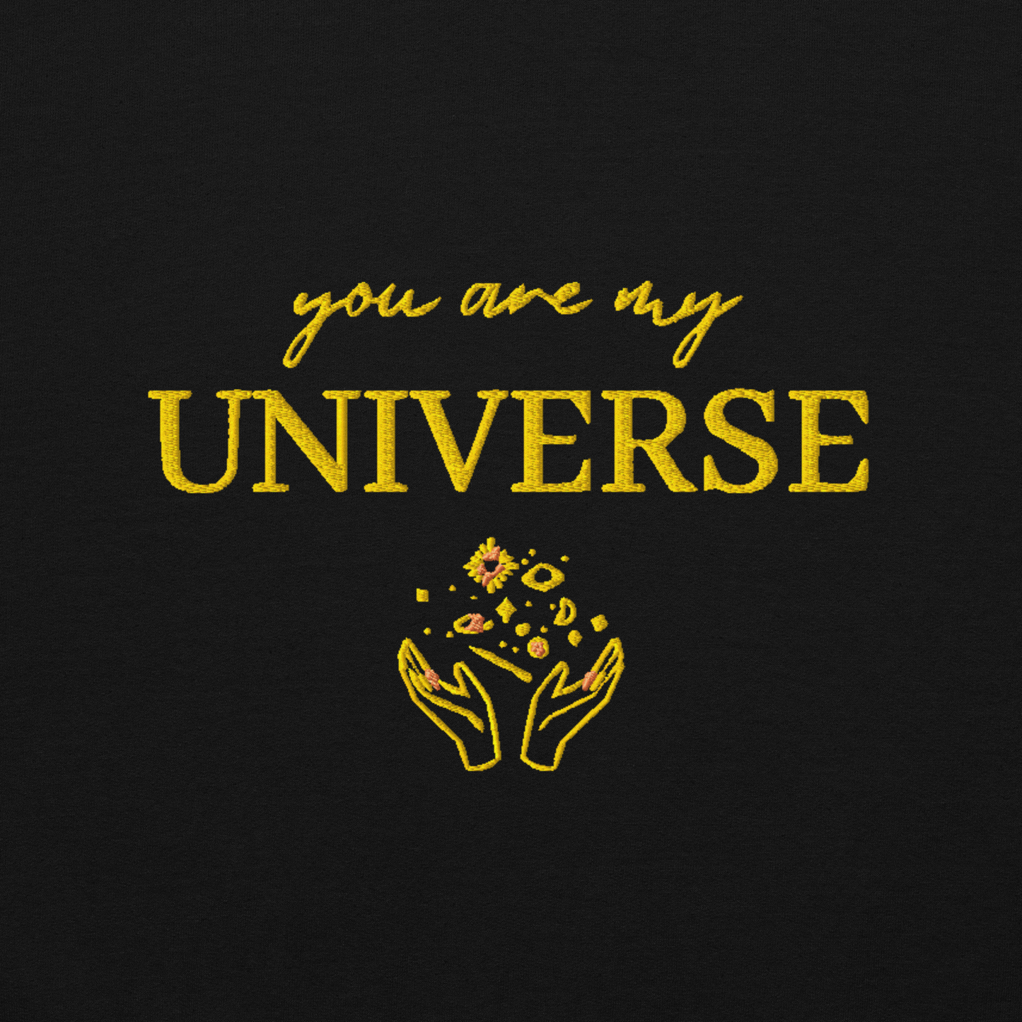 Black crewneck sweatshirt featuring yellow typography that reads “you are my Universe” with minimalist hands holding stars illustration -inspired by Coldplay’s hit song “My Universe”, aesthetic fan apparel for music lovers.