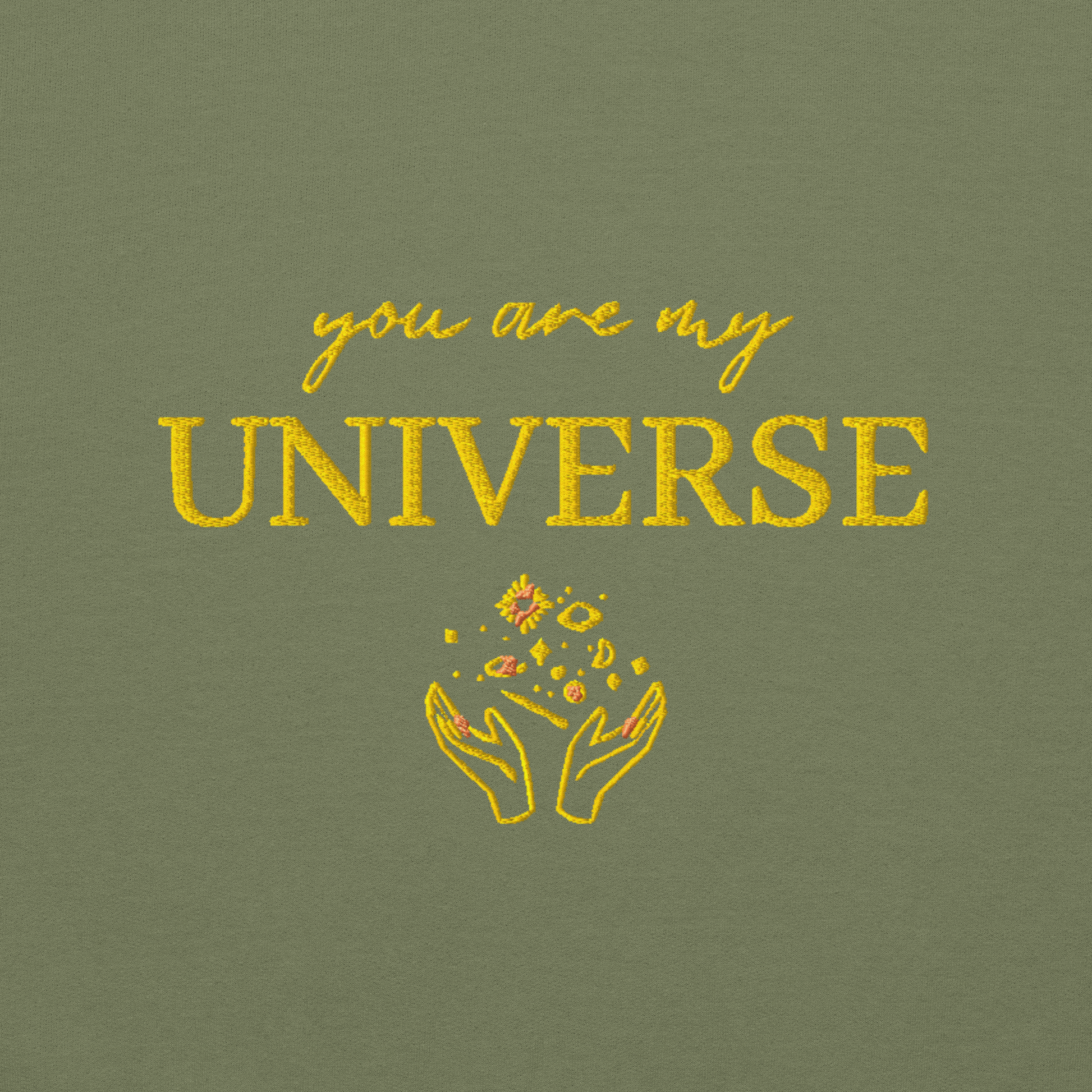Green crewneck sweatshirt featuring yellow typography that reads “you are my Universe” with minimalist hands holding stars illustration -inspired by Coldplay’s hit song “My Universe”, aesthetic fan apparel for music lovers.