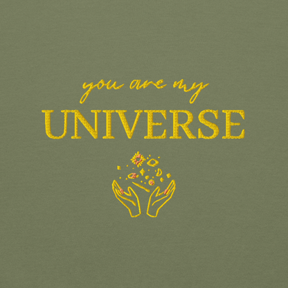Green crewneck sweatshirt featuring yellow typography that reads “you are my Universe” with minimalist hands holding stars illustration -inspired by Coldplay’s hit song “My Universe”, aesthetic fan apparel for music lovers.