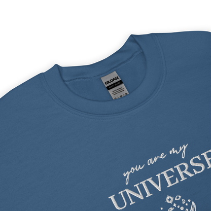 Indigo blue crewneck sweatshirt featuring white typography that reads “you are my Universe” with minimalist hands holding stars illustration -inspired by Coldplay’s hit song “My Universe”, aesthetic fan apparel for music lovers.