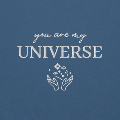 Indigo blue crewneck sweatshirt featuring white typography that reads “you are my Universe” with minimalist hands holding stars illustration -inspired by Coldplay’s hit song “My Universe”, aesthetic fan apparel for music lovers.