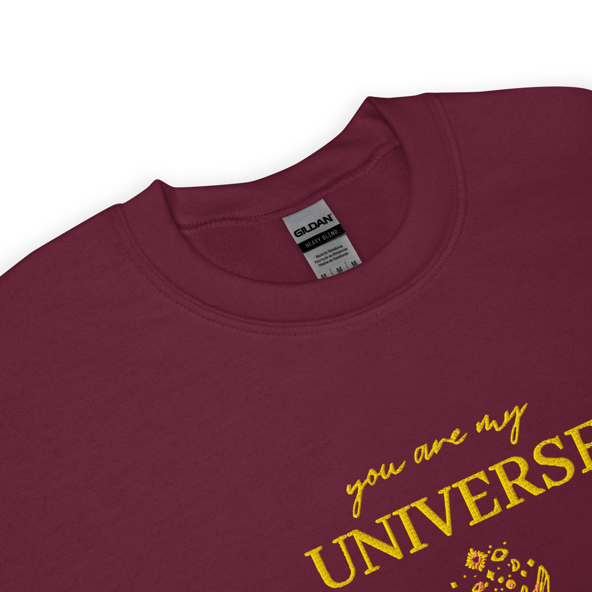 Maroon crewneck sweatshirt featuring yellow typography that reads “you are my Universe” with minimalist hands holding stars illustration -inspired by Coldplay’s hit song “My Universe”, aesthetic fan apparel for music lovers.