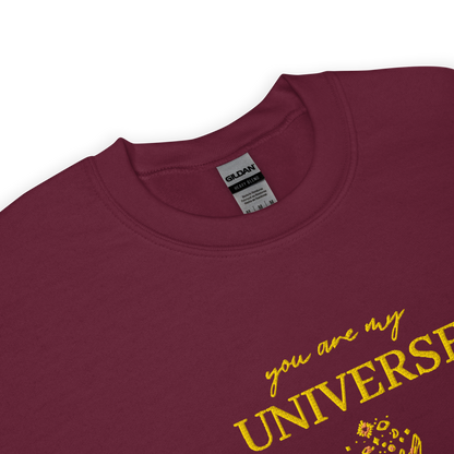 Maroon crewneck sweatshirt featuring yellow typography that reads “you are my Universe” with minimalist hands holding stars illustration -inspired by Coldplay’s hit song “My Universe”, aesthetic fan apparel for music lovers.