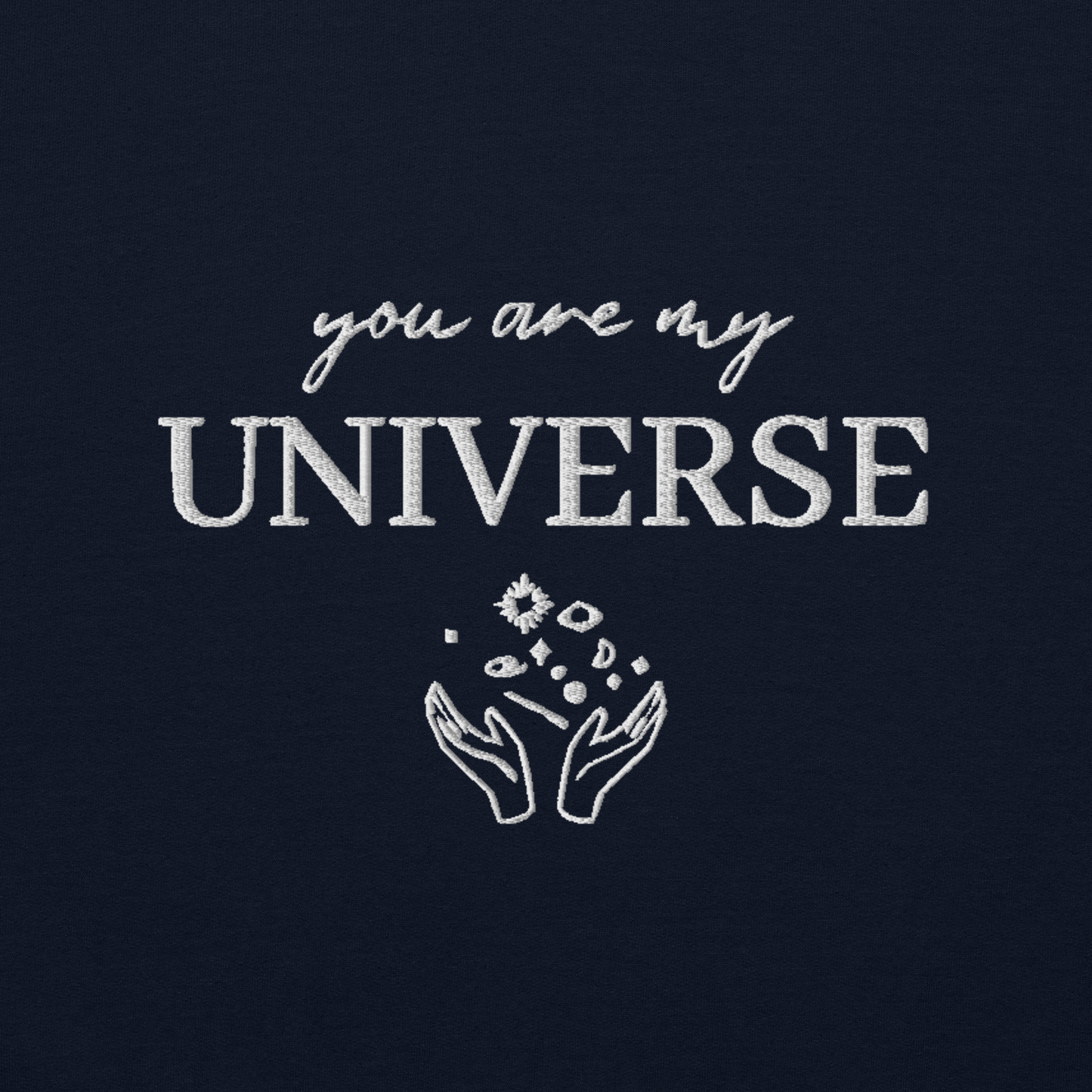 Navy crewneck sweatshirt featuring white typography that reads “you are my Universe” with minimalist hands holding stars illustration -inspired by Coldplay’s hit song “My Universe”, aesthetic fan apparel for music lovers.