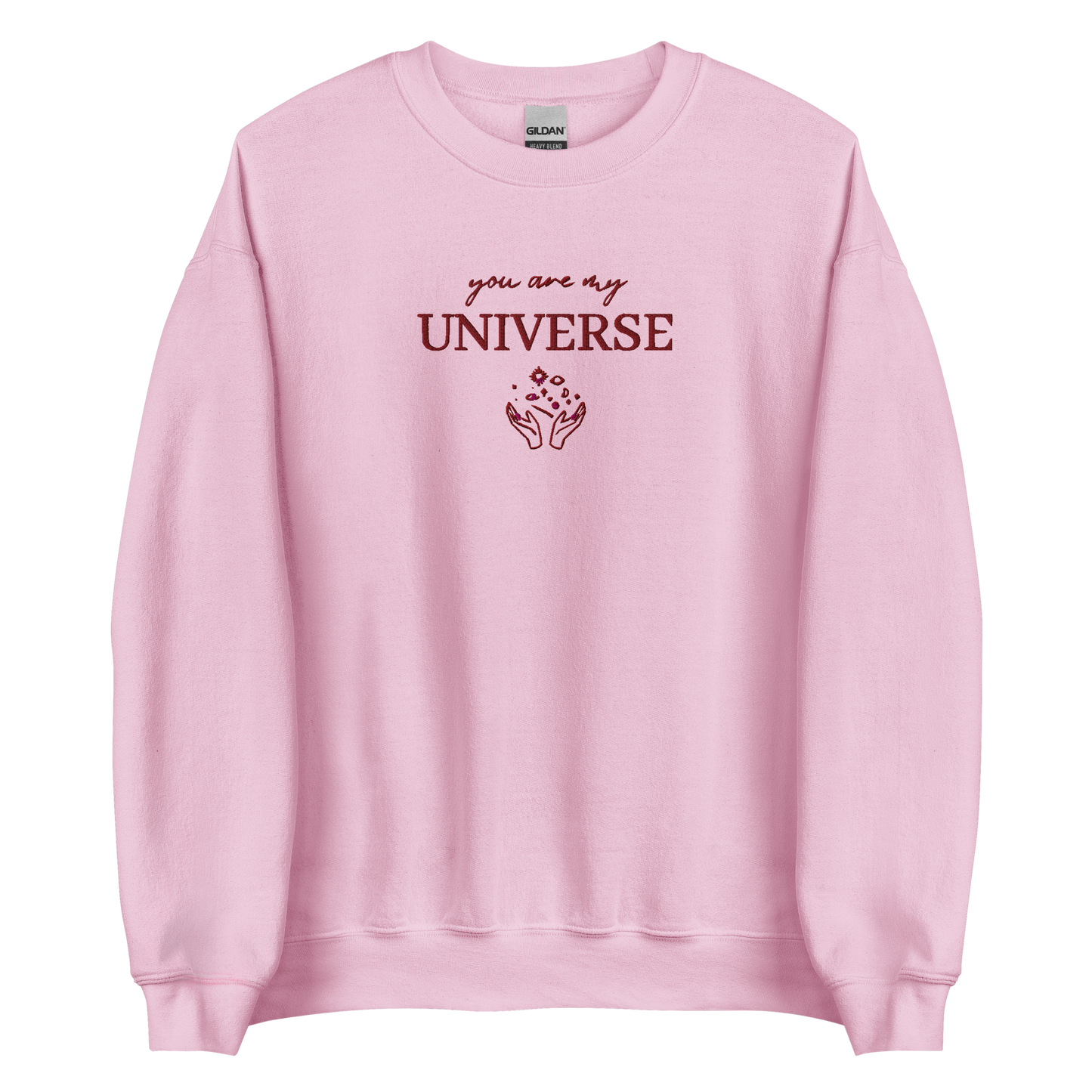 Pink crewneck sweatshirt featuring maroon typography that reads “you are my Universe” with minimalist hands holding stars illustration -inspired by Coldplay’s hit song “My Universe”, aesthetic fan apparel for music lovers.
