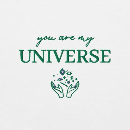 White crewneck sweatshirt featuring green typography that reads “you are my Universe” with minimalist hands holding stars illustration -inspired by Coldplay’s hit song “My Universe”, aesthetic fan apparel for music lovers.