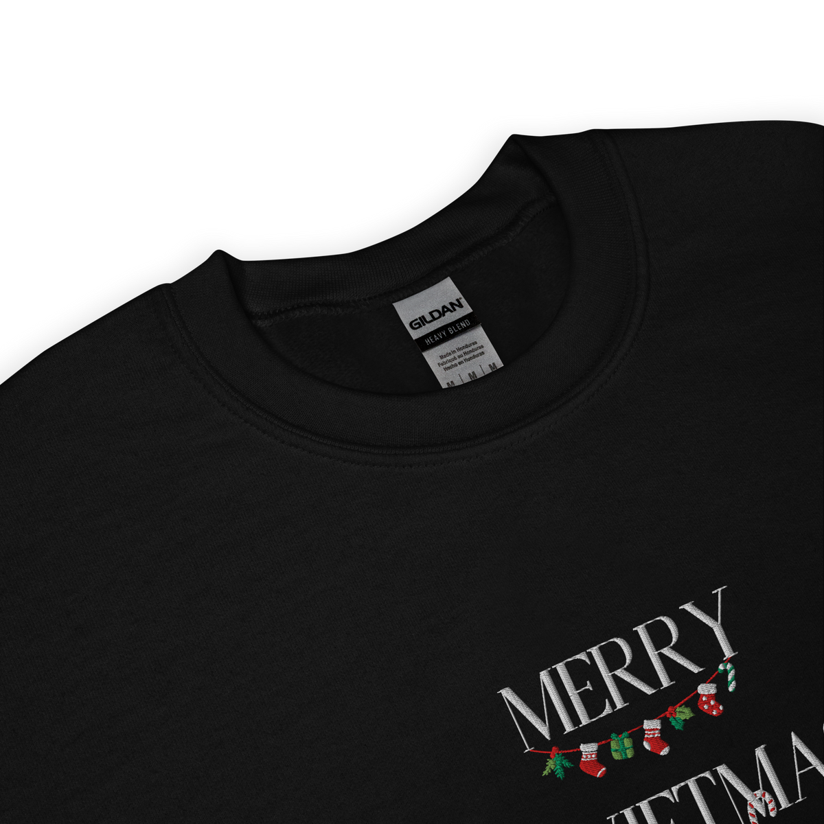 Black sweatshirt, close-up view of "Merry Swiftmas" embroidered text with a stocking garland and candy cane, holiday Taylor Swift design