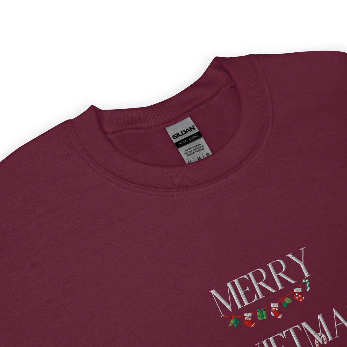 Maroon sweatshirt, close-up view of "Merry Swiftmas" embroidered text with a stocking garland and candy cane, holiday Taylor Swift design