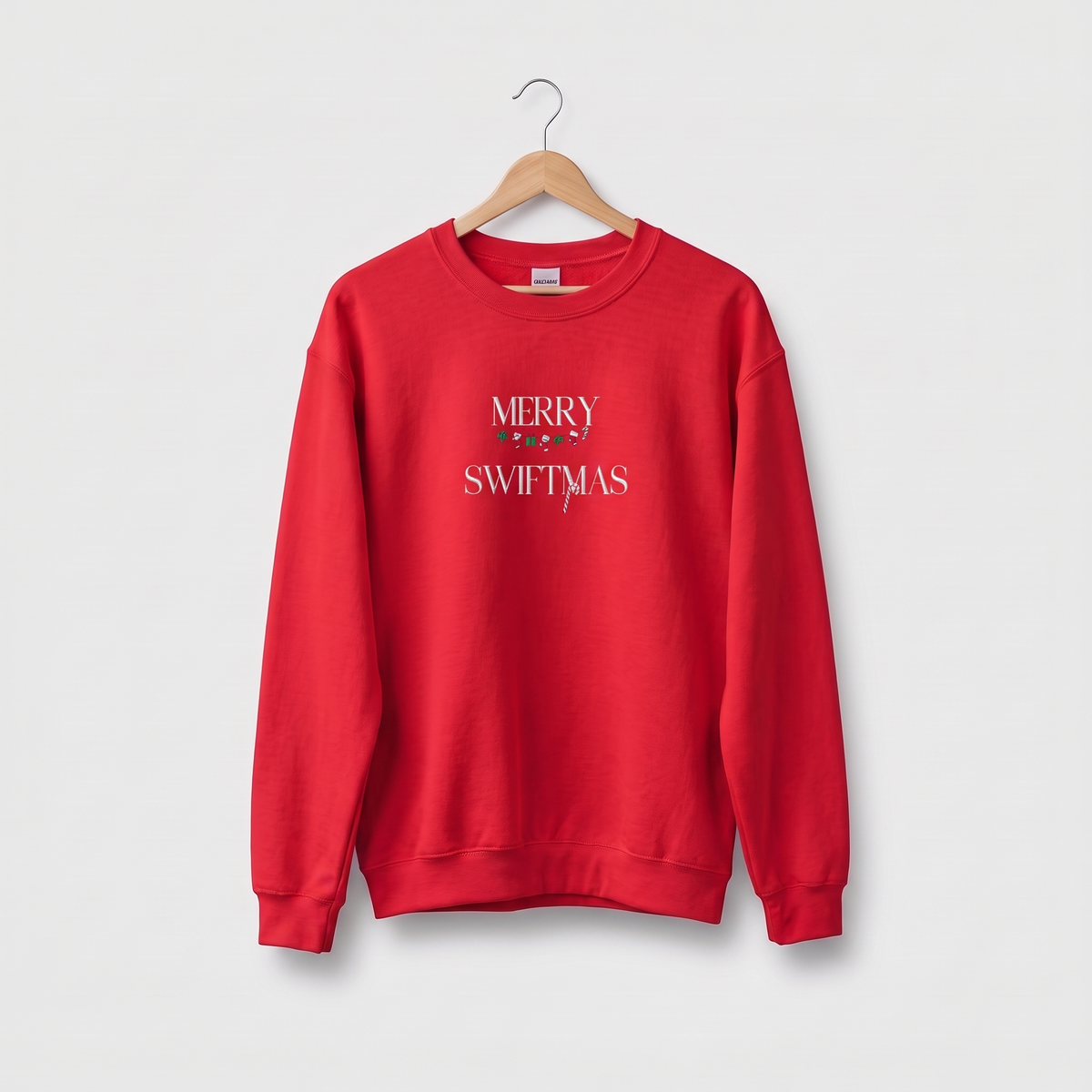 Red sweatshirt with "Merry Swiftmas" embroidered text with a stocking garland and candy cane, holiday Taylor Swift design