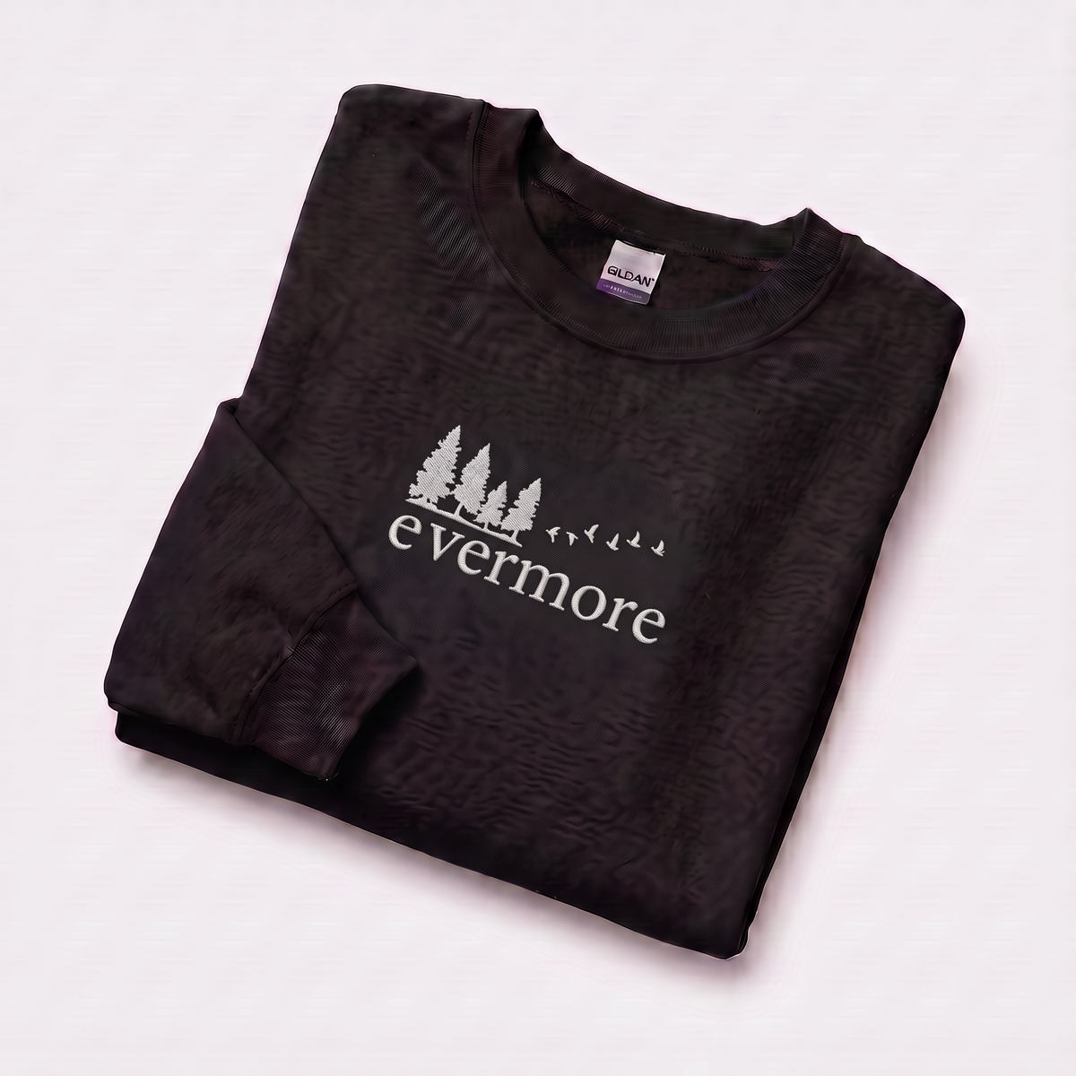 Folded black evermore era sweatshirt, Taylor Swift-inspired embroidered forest and bird design, cozy cottagecore crewneck for Swifties