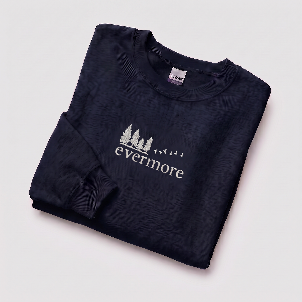 Folded navy evermore era sweatshirt, Taylor Swift-inspired embroidered forest and bird design, cozy cottagecore crewneck for Swifties