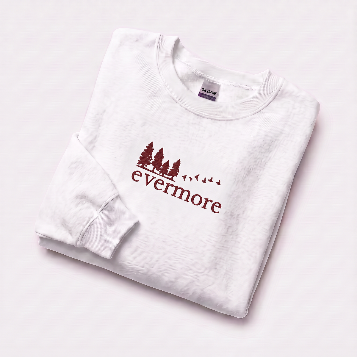Folded white evermore era sweatshirt, Taylor Swift-inspired embroidered forest and bird design, cozy cottagecore crewneck for Swifties