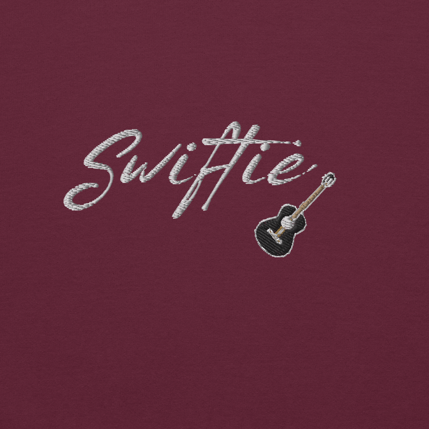 Maroon crewneck sweatshirt with white “Swiftie” script and small guitar graphic on the chest, Taylor Swift inspired fan merch, cozy unisex pullover for concerts and everyday wear