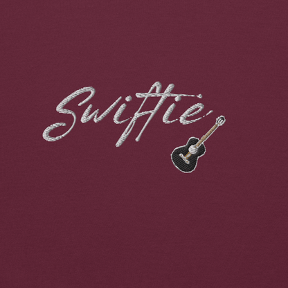 Maroon crewneck sweatshirt with white “Swiftie” script and small guitar graphic on the chest, Taylor Swift inspired fan merch, cozy unisex pullover for concerts and everyday wear