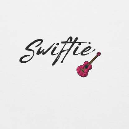 White crewneck sweatshirt with black “Swiftie” script and small guitar graphic on the chest, Taylor Swift inspired fan merch, cozy unisex pullover for concerts and everyday wear