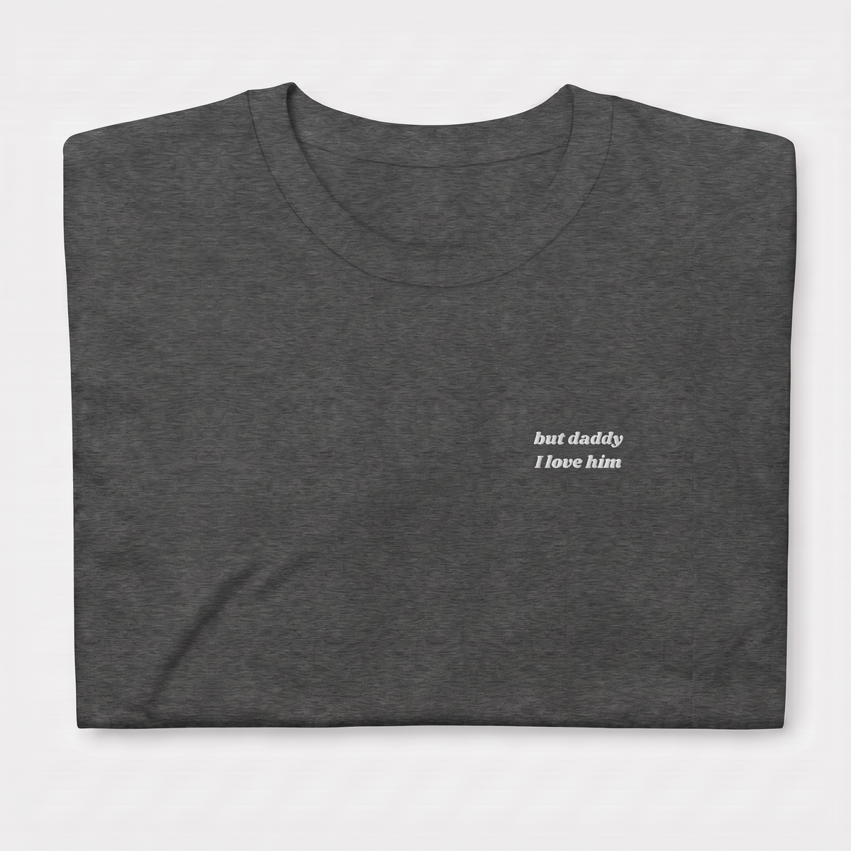 Close-up of 'but daddy I love him' embroidered in white script text on a dark heather Taylor Swift t-shirt, Tortured Poets Department inspired design