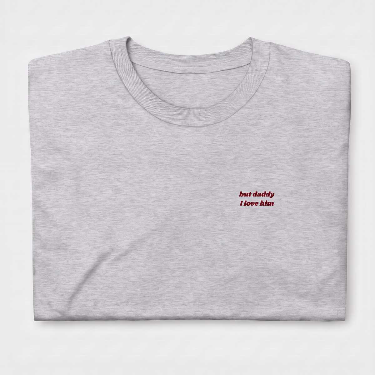 Close-up of 'but daddy I love him' embroidered in red script text on a grey Taylor Swift t-shirt, Tortured Poets Department inspired design