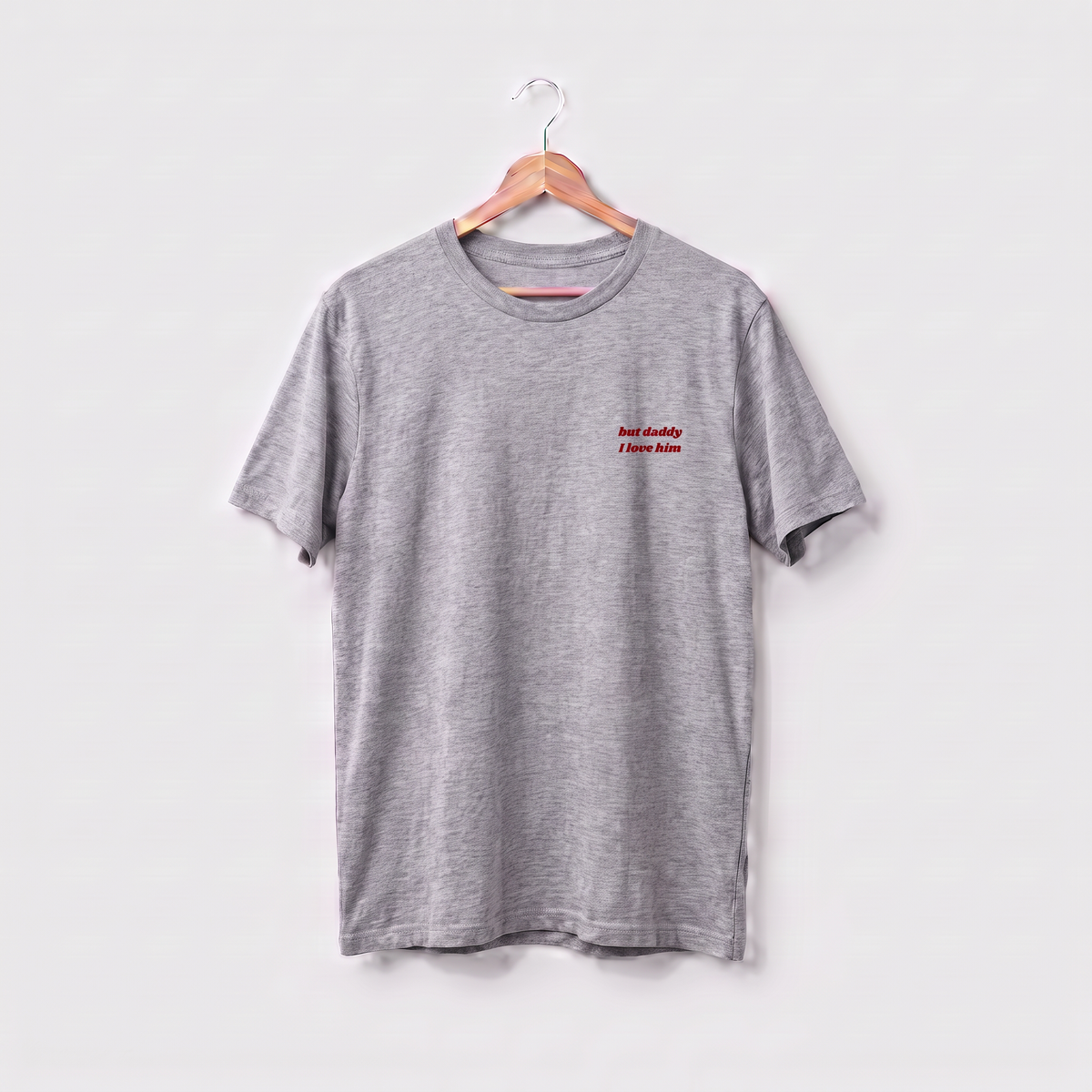 Grey Taylor Swift t-shirt embroidered with 'but daddy I love him' in white script text on the left chest.