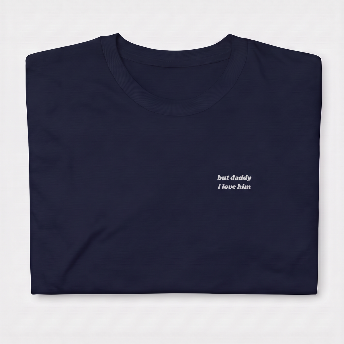 Close-up of 'but daddy I love him' embroidered in white script text on a blue Taylor Swift t-shirt, Tortured Poets Department inspired design