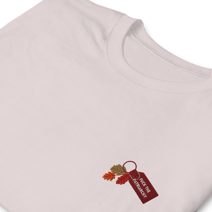 Grey t-shirt with small embroidered “Fuck the Patriarchy” keychain design and autumn leaves inspired by Taylor Swift’s All Too Well lyric, minimalist Swiftie fan shirt