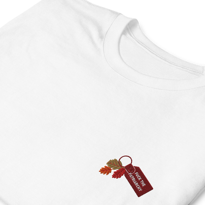 White t-shirt with small embroidered “Fuck the Patriarchy” keychain design and autumn leaves inspired by Taylor Swift’s All Too Well lyric, minimalist Swiftie fan shirt