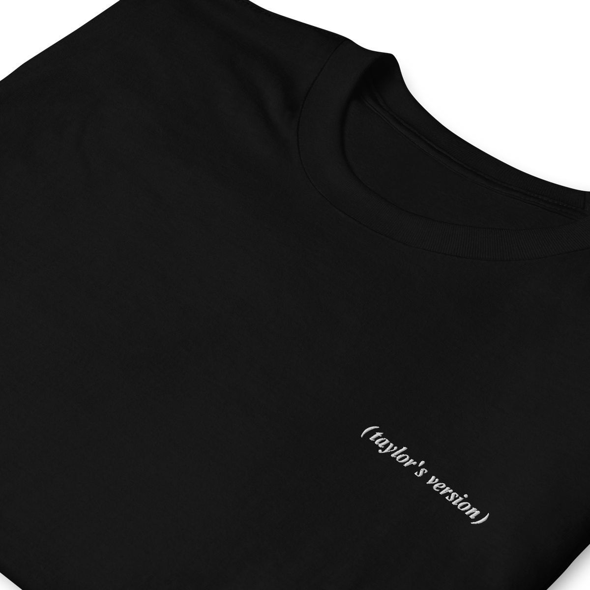 Close-up of a black t-shirt with "(taylor's version)" embroidered in script text