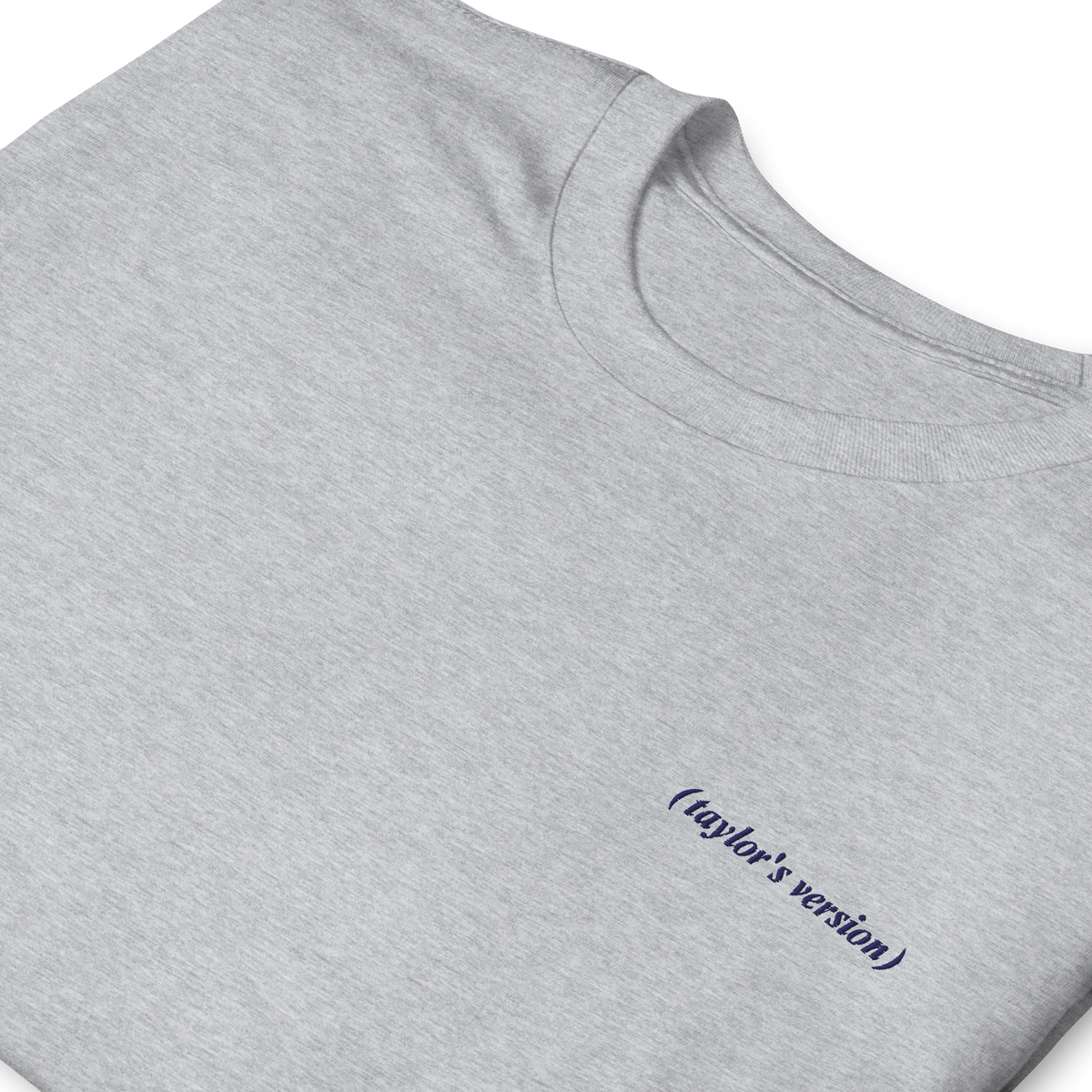 Close-up of a grey t-shirt with "(taylor's version)" embroidered in script text